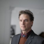 Portrait of a businessman in a formal suit in an indoor setting.